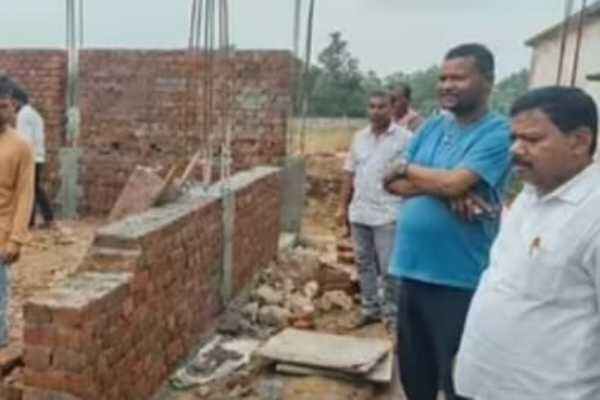 डस्ट से बनी स्कूल भवन की दीवार को तोड़ते कर्मी