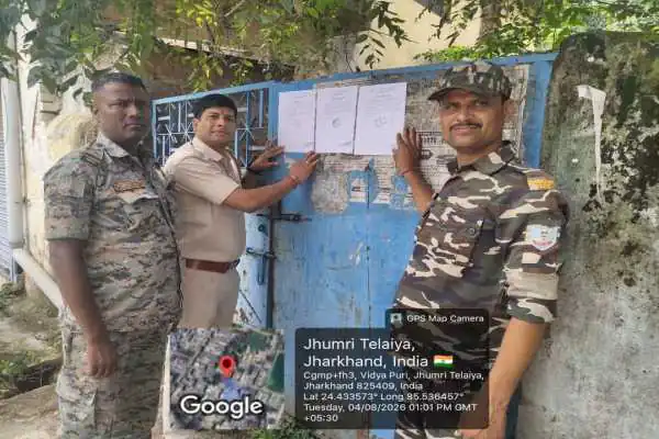 फरार आरोपियों के घर इश्तेहार चिपकाती तिलैया थाना पुलिस